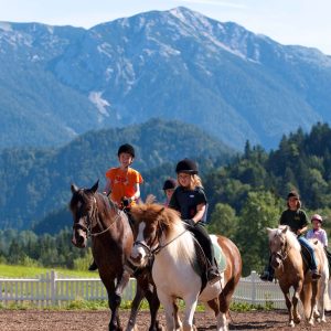 Pferde Reiten im Urlaub, Mädchen reitet auf dem Pferd, Berge im Hintergrund, Kinder Erholung im Urlaub, Aktiv im Urlaub